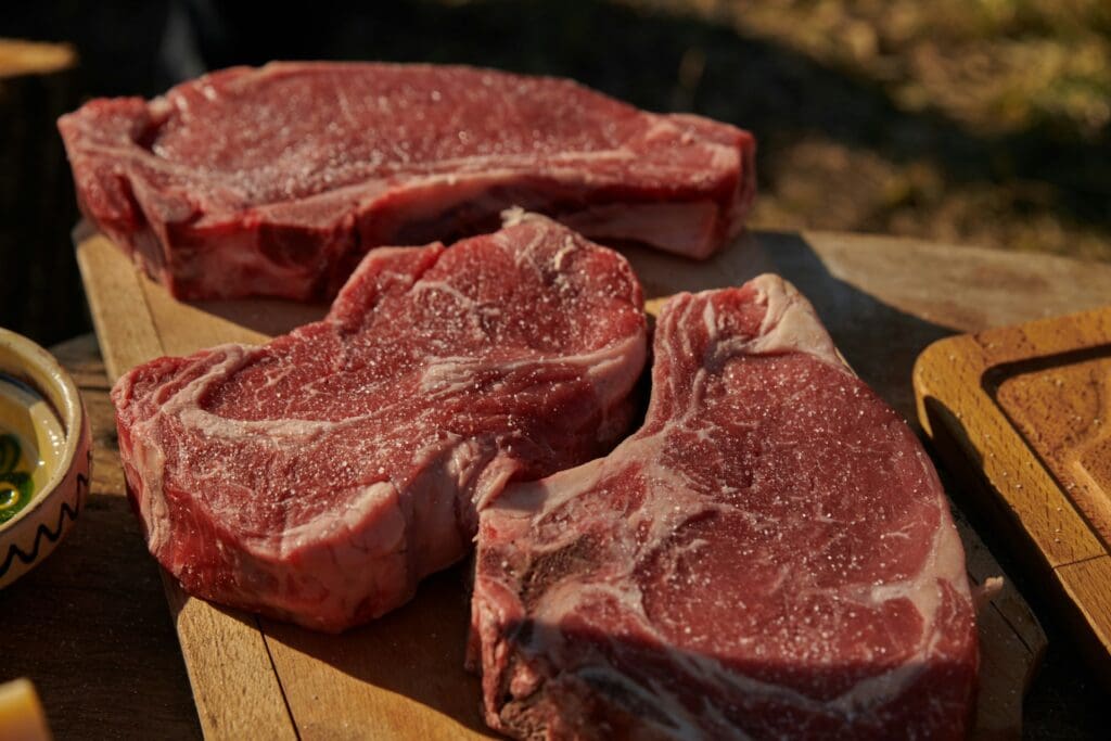 Gesalzene Färsensteaks auf dem Holzbrett – ideal für Rubs und den Grill