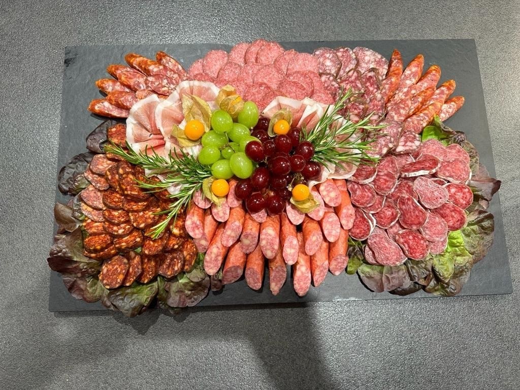 Zünftige Brotzeitplatte mit Wurst, Käse, Obazda und Garnitur – bayerisches Catering für Firmenfeier, Hochzeit oder Sommerfest in München.